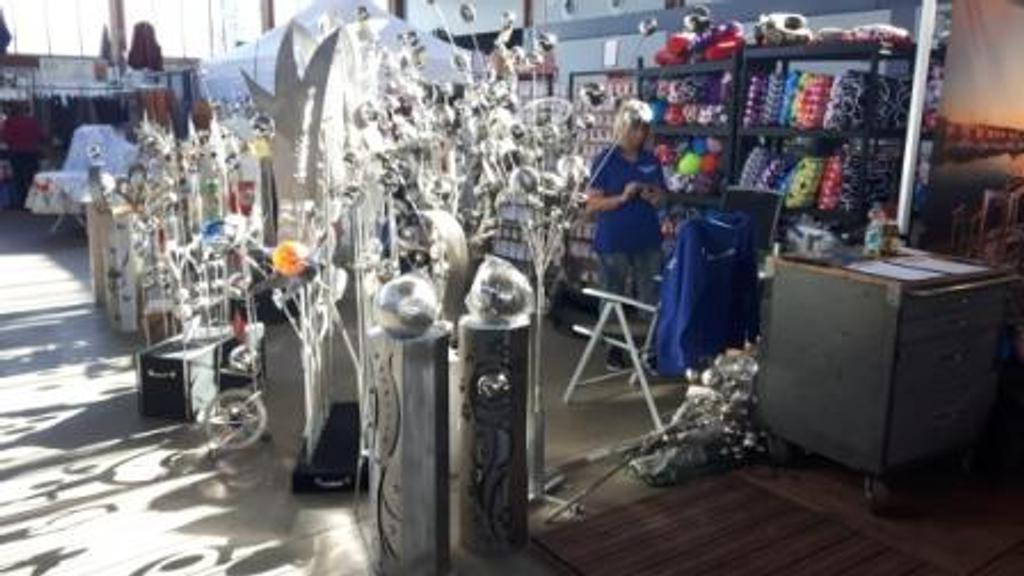 Ein Mann in einem blauen Hemd steht in einem Geschäft und schaut auf sein Telefon.