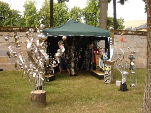 Ein grünes Zelt mit einer Reihe von Skulpturen davor