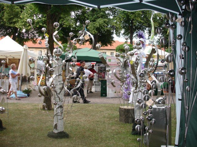 Eine Gruppe von Menschen steht unter einem Zelt in einem Park