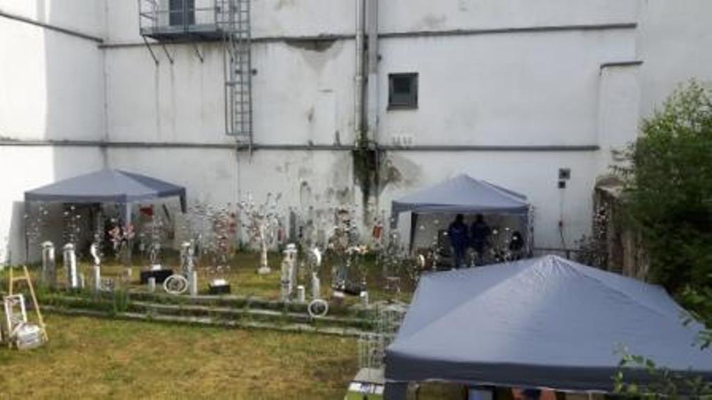 Eine Gruppe Zelte steht vor einem weißen Gebäude.