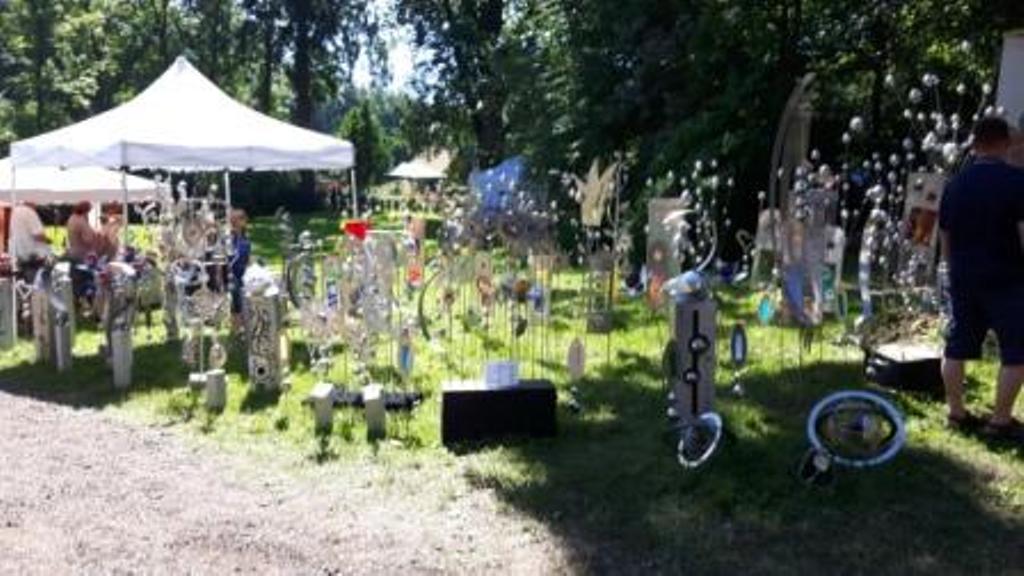 Ein Mann steht vor einer Skulpturenausstellung in einem Park.