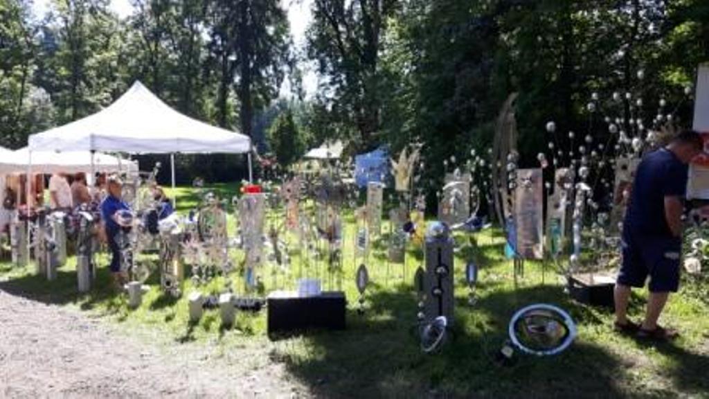 Ein Mann steht vor einer Skulpturenausstellung in einem Park.