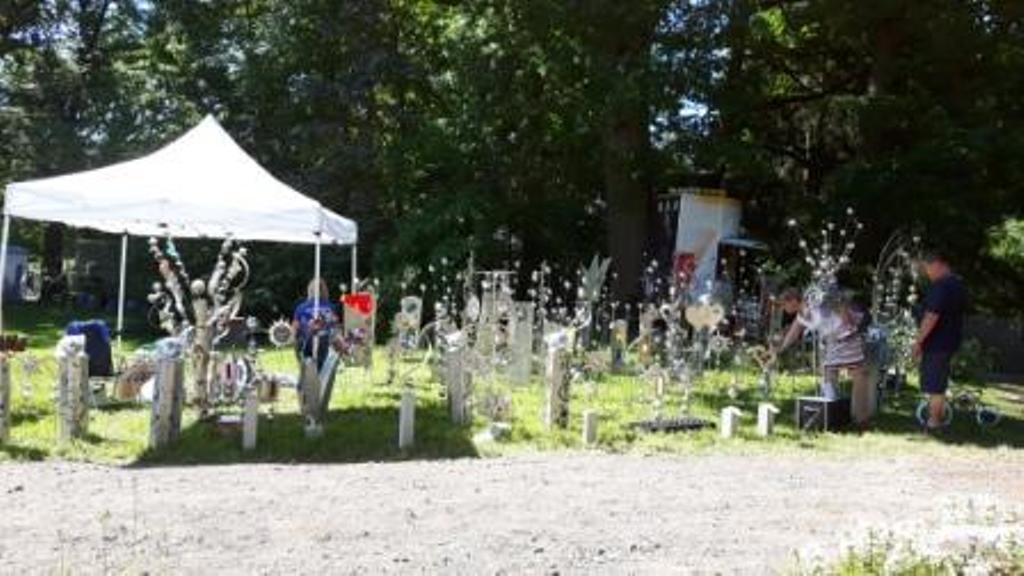 Eine Gruppe von Menschen steht vor einem Friedhof.