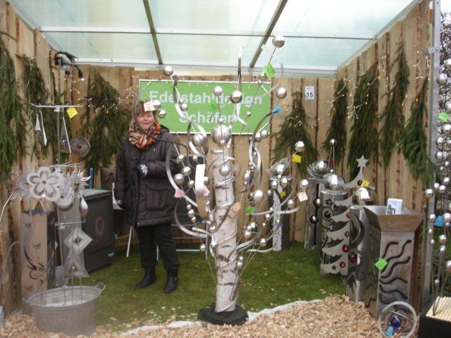 Eine Frau steht vor einem Schild mit der Aufschrift „Edelstahl“