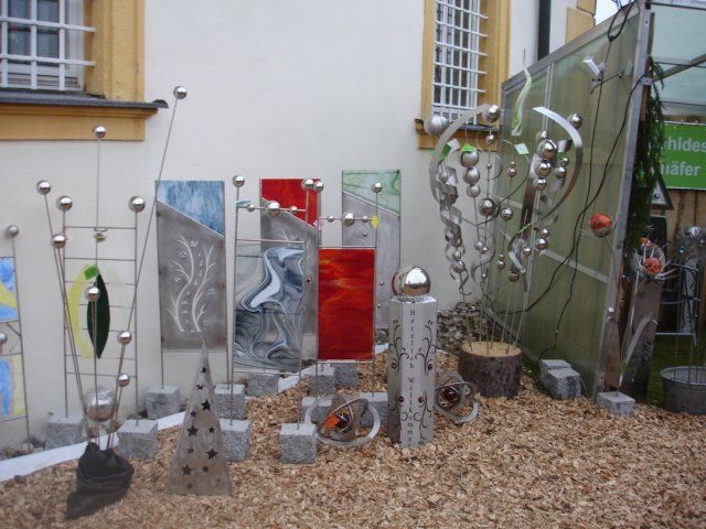 Eine Ausstellung von Buntglas-Skulpturen vor einem Gebäude