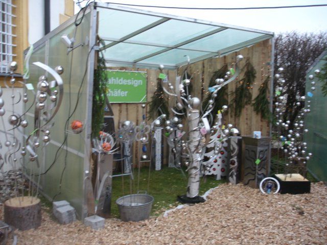 Ein grünes Schild an einem Holzzaun sagt Webdesign Atelier