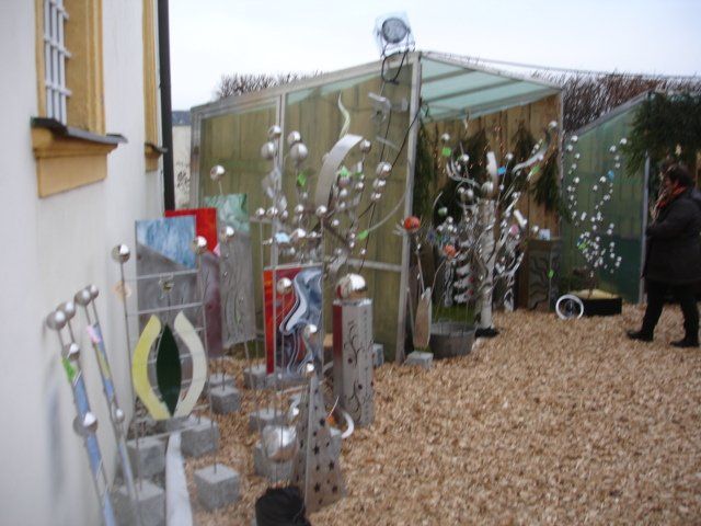 Eine Person steht vor einem Gebäude mit einer Reihe von Skulpturen auf dem Boden