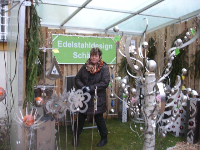 Eine Frau steht vor einem Schild mit der Aufschrift „Edelstahldesign“