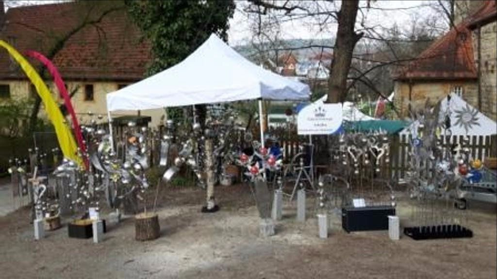 Mitten in einem Park steht ein weißes Zelt.