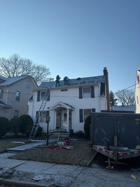 Two men are working on the roof of a house