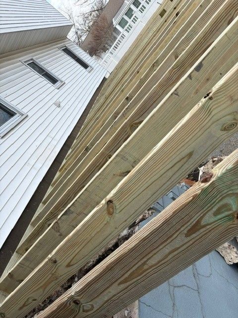 A wooden structure is being built in front of a house.