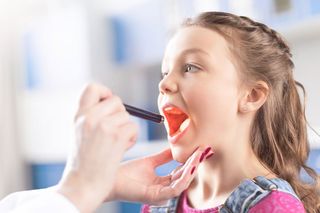 Doctor Checking Throat of Little Girl — Framingham, MA — Metrowest Ear, Nose & Throat Associates