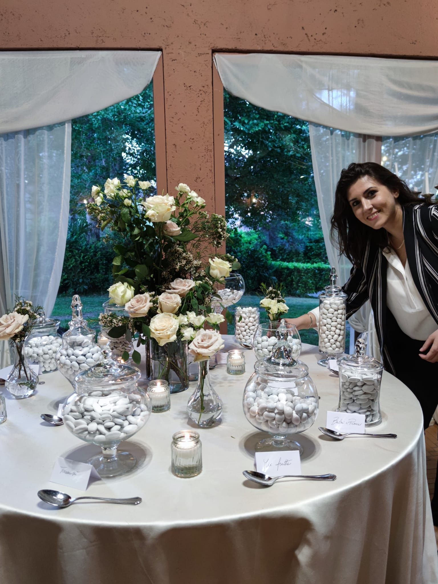 una donna in piedi davanti a un tavolo pieno di confetti e fiori