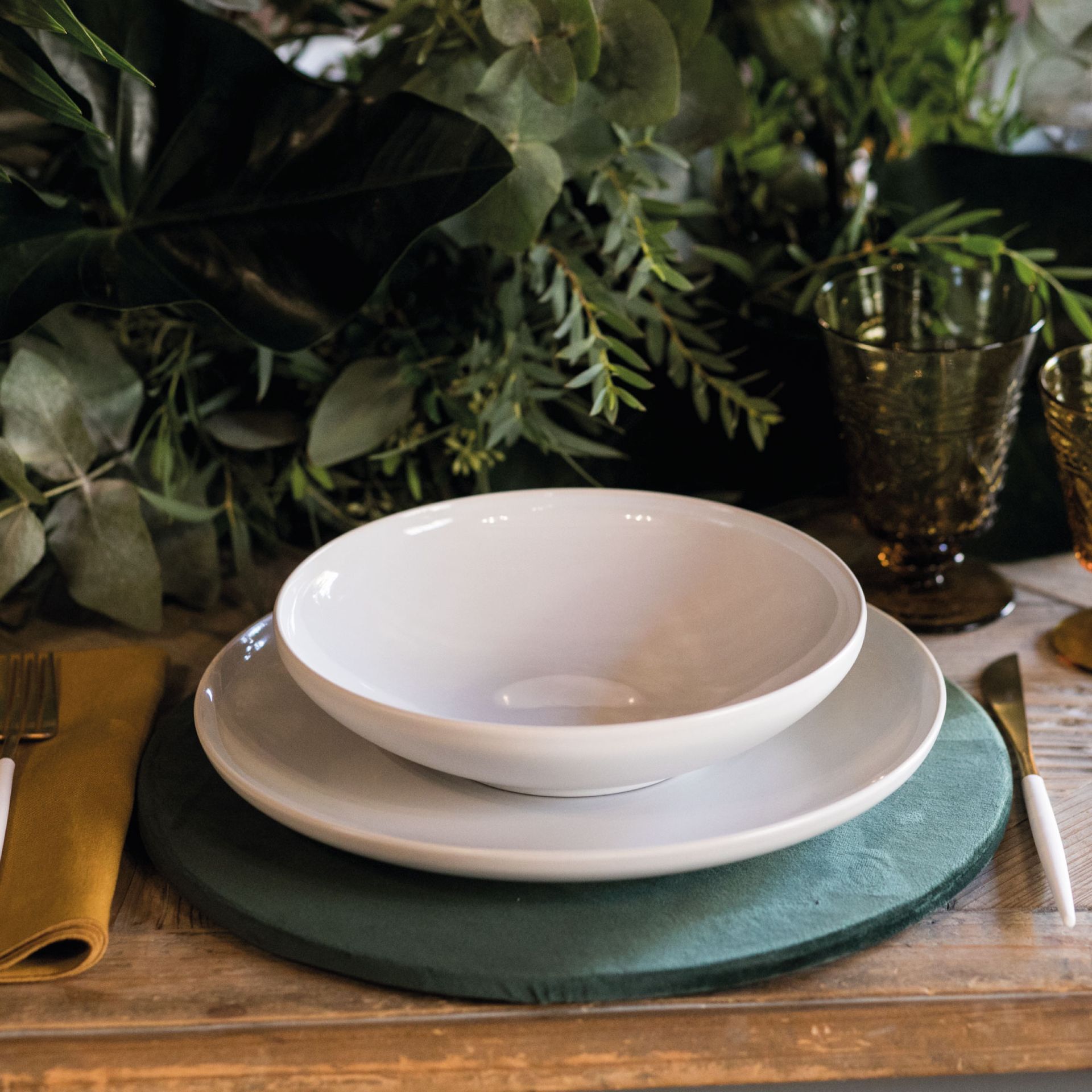 a table with plates and glasses on a green napkin