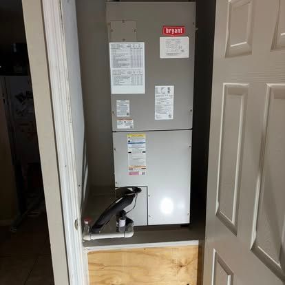 HVAC unit in a closet. The unit is gray, with various informational stickers. The door is white.