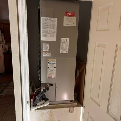 Bryant HVAC unit in a utility closet with a white door.