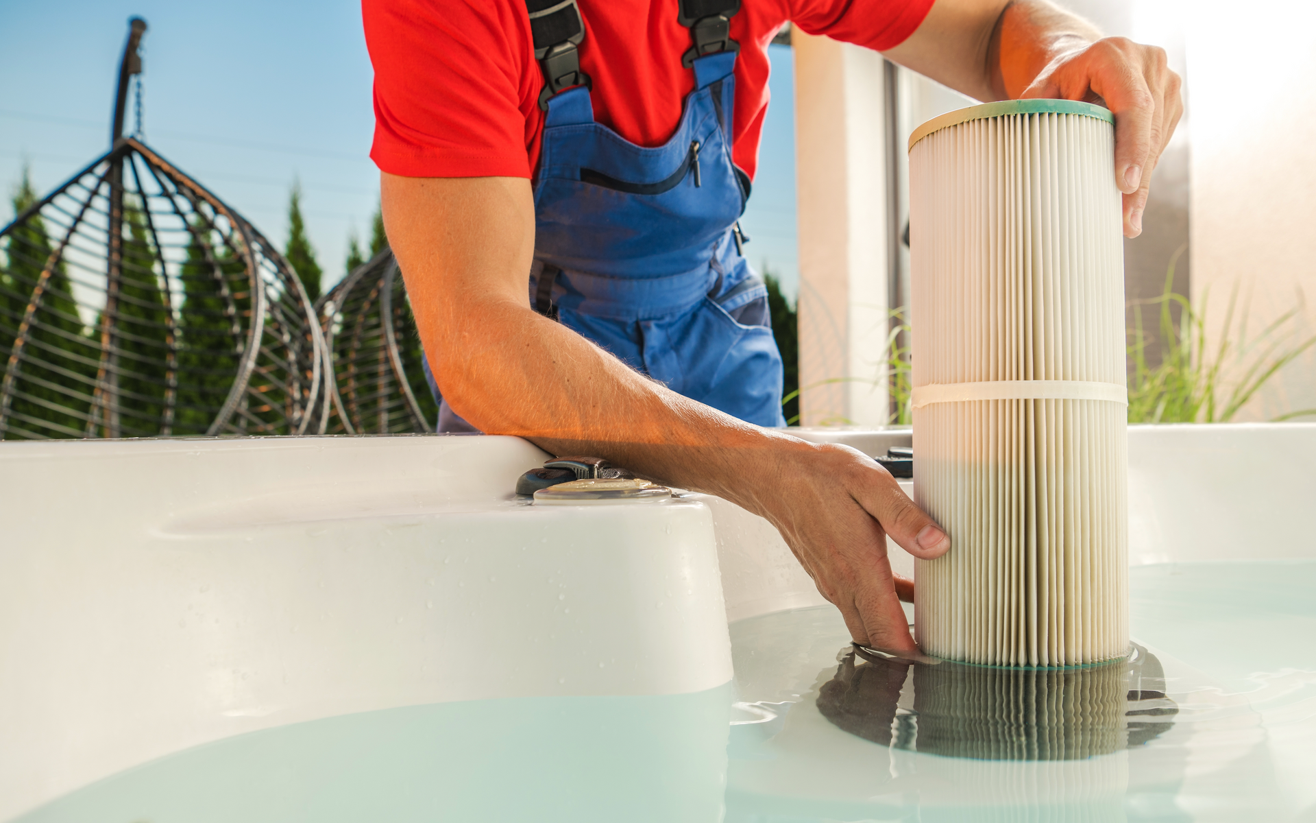 Person in overalls replacing a spa filter in a hot tub.