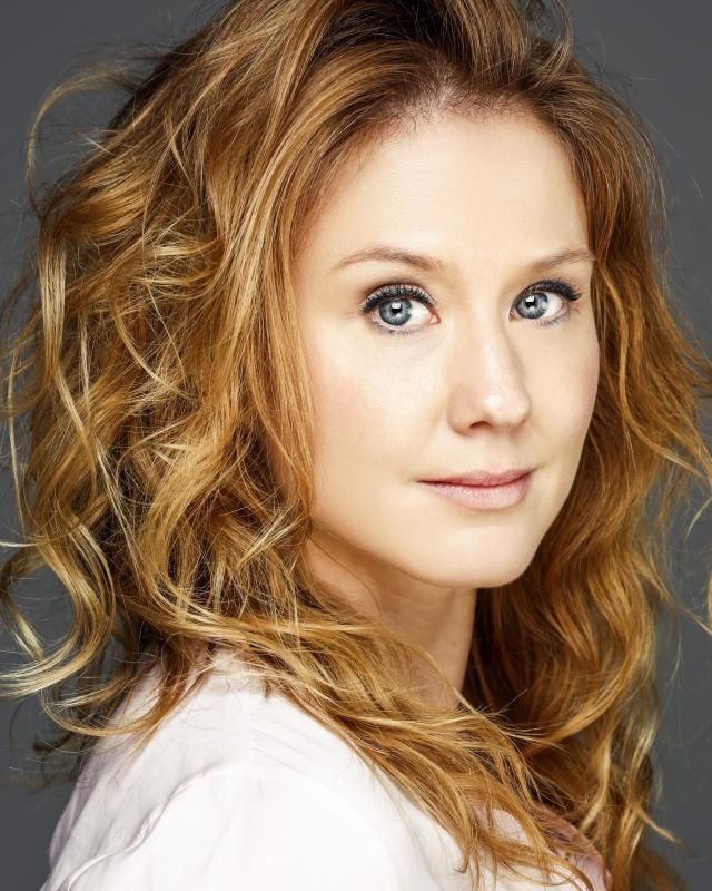 A close up of a woman 's face with blonde hair and blue eyes