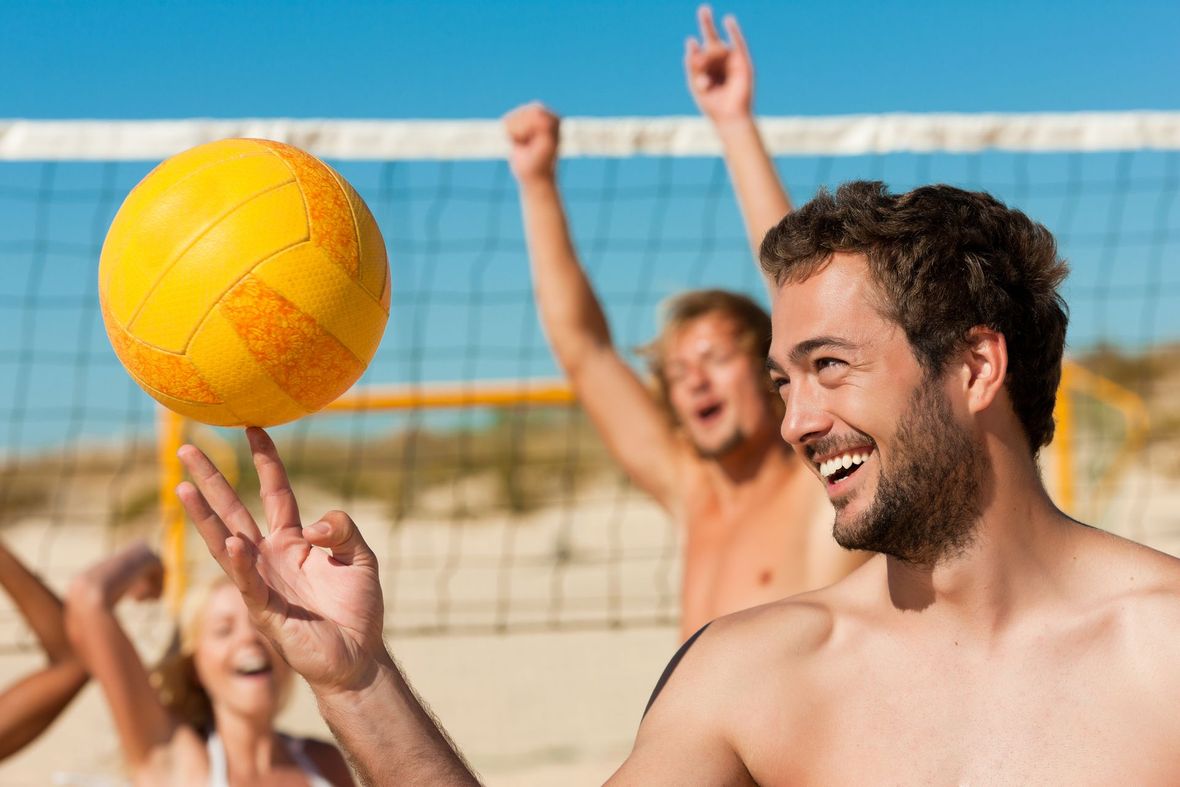A group of people are playing volleyball on the beach.