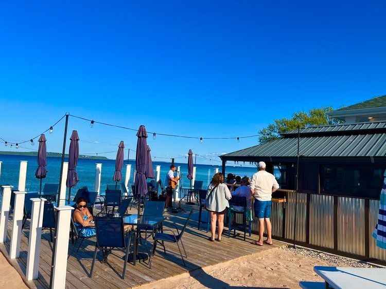 A woman in a green shirt is laughing with her mouth open