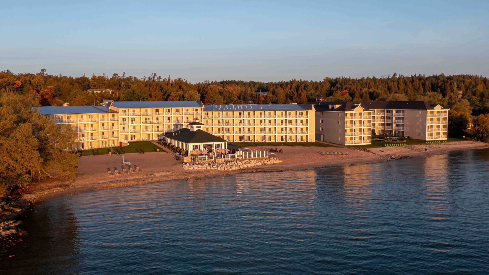 A large building is sitting on the shore of a lake.