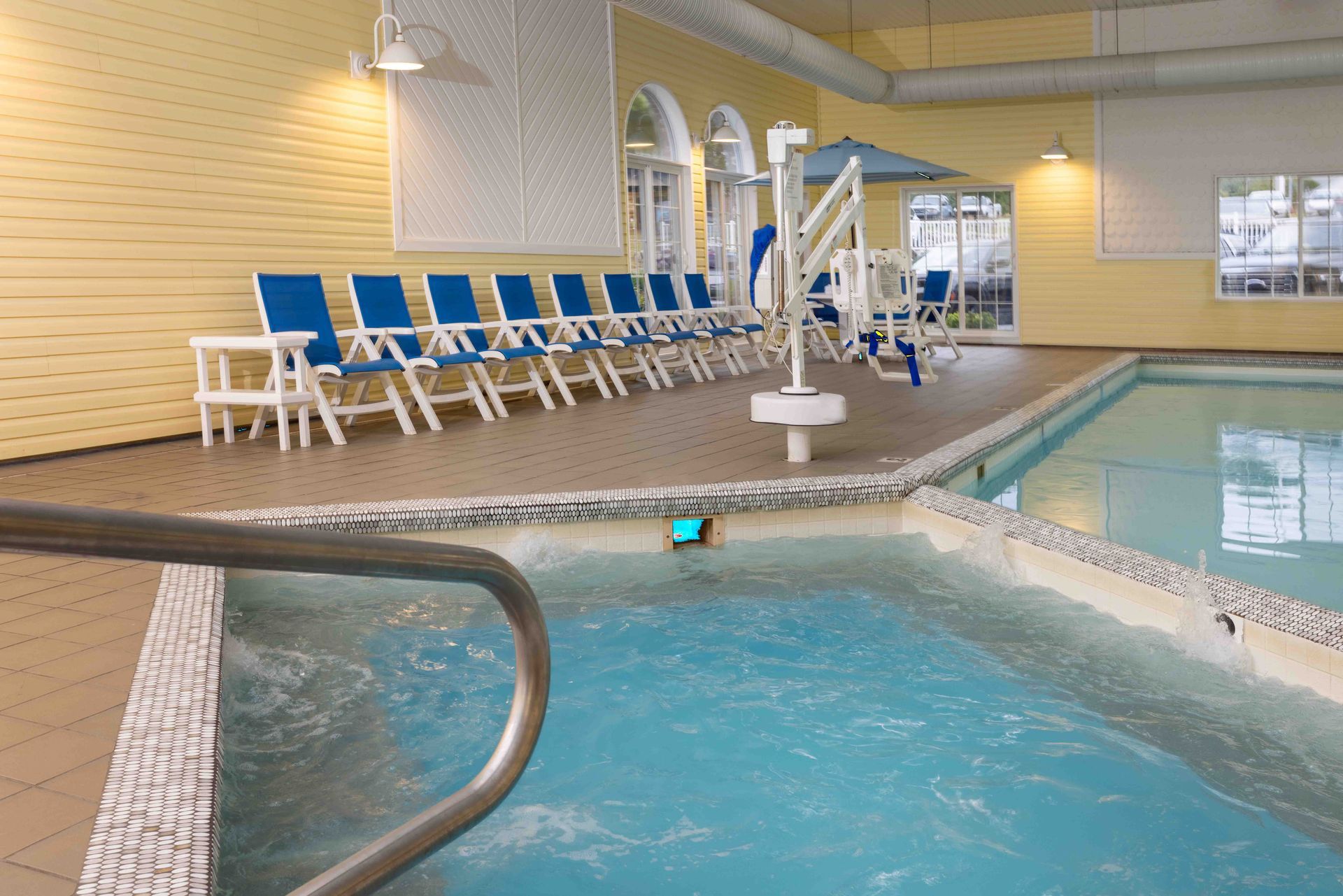 A large indoor swimming pool with chairs and umbrellas
