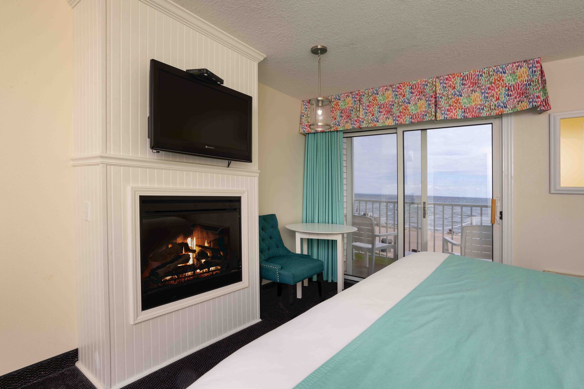 A hotel room with a fireplace and a flat screen tv.