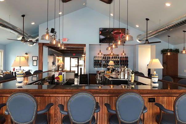 A large room with a bar and chairs in it