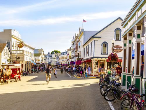 A group of people are walking down a busy street in a small town.
