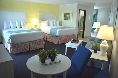 A hotel room with two beds and a living room