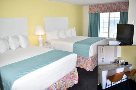 A hotel room with two beds and a flat screen tv