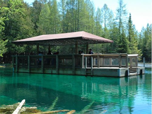 A boat is floating on top of a lake surrounded by trees.