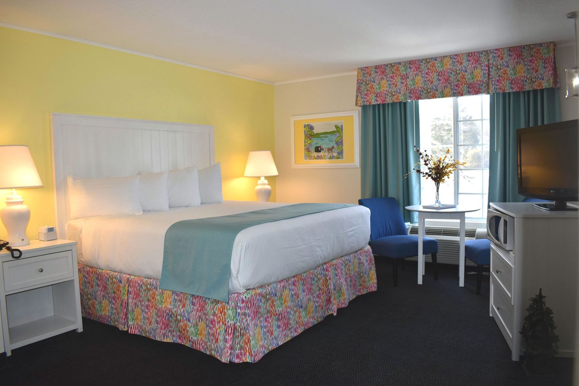 A hotel room with a king size bed and a television