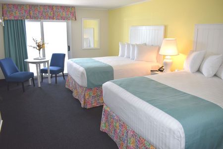 A hotel room with two beds , a table and chairs.