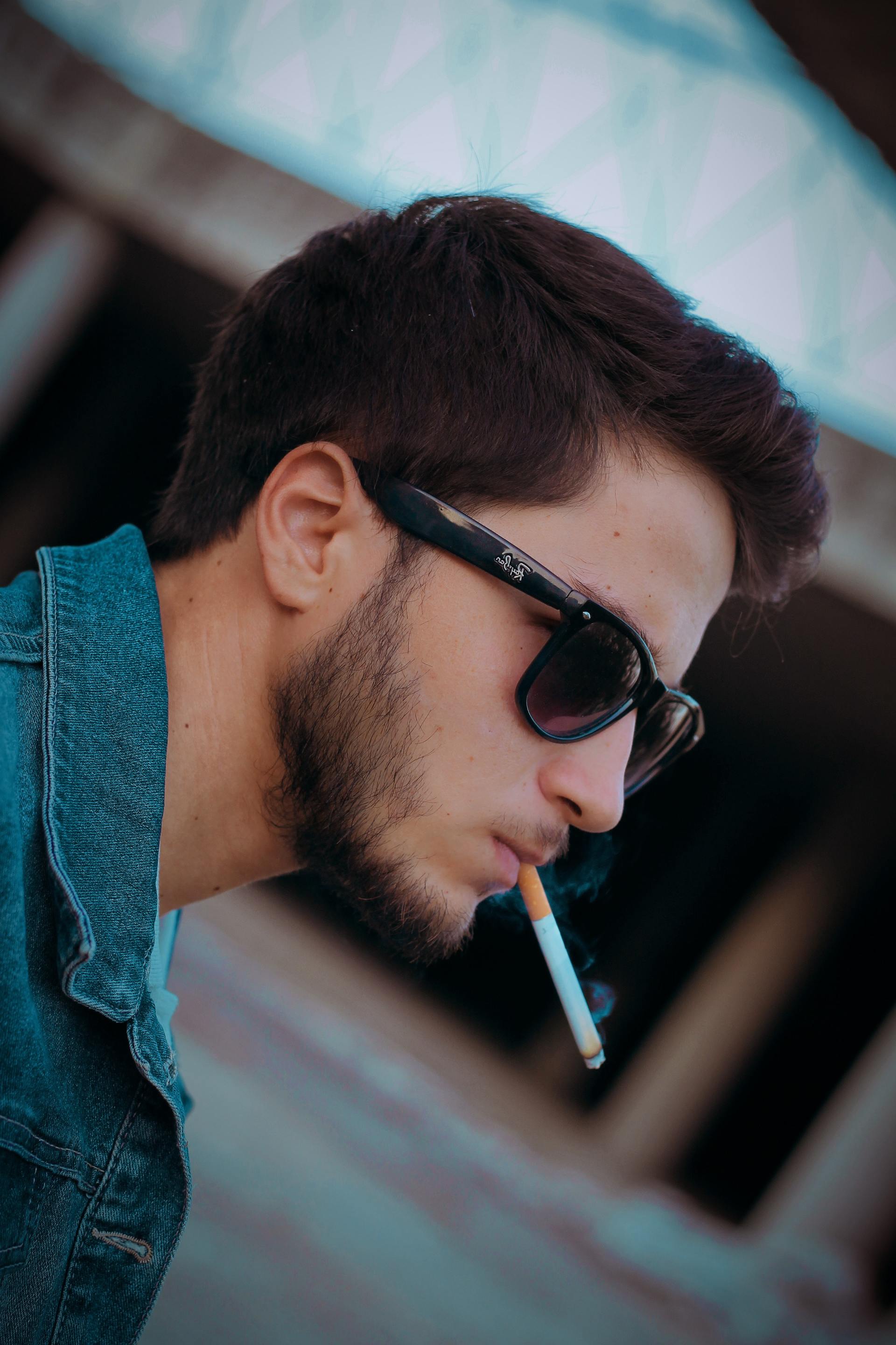 person with sunglasses smoking a cigarette
