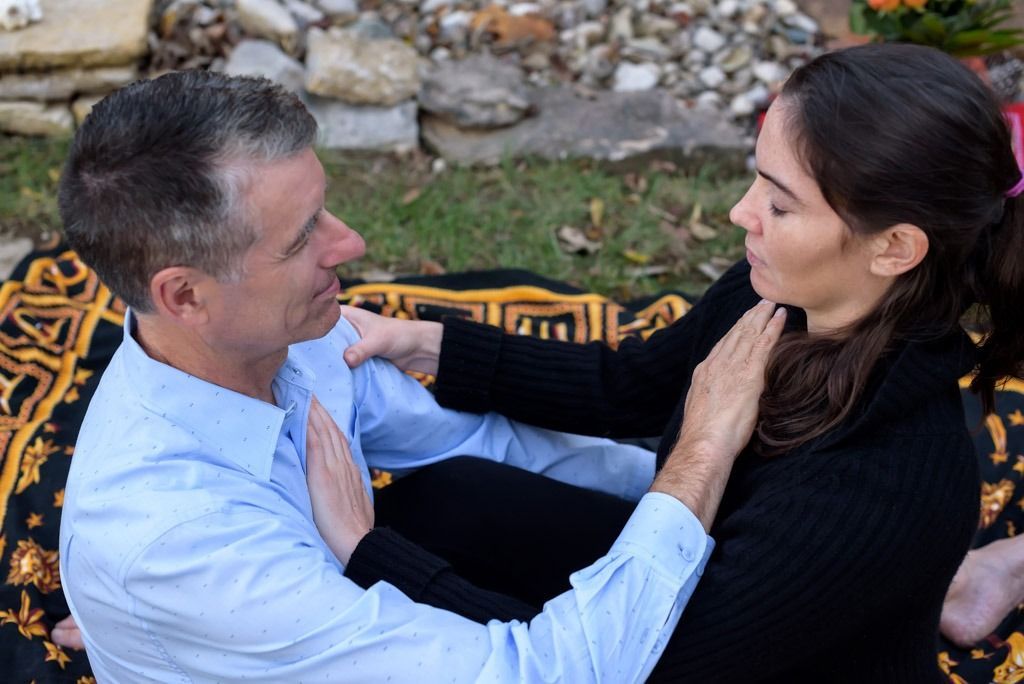 A man and a woman are sitting next to each other on a blanket.