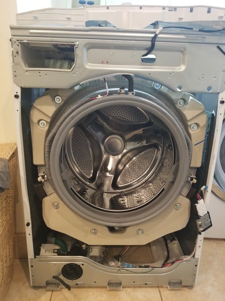 The inside of a washing machine is shown with the door open.