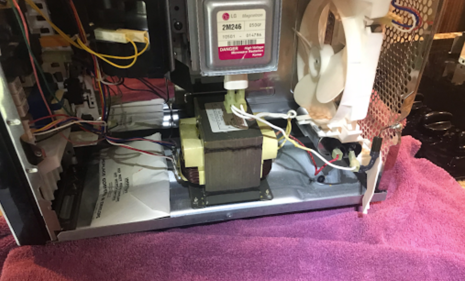 The inside of a microwave with a fan attached to it.
