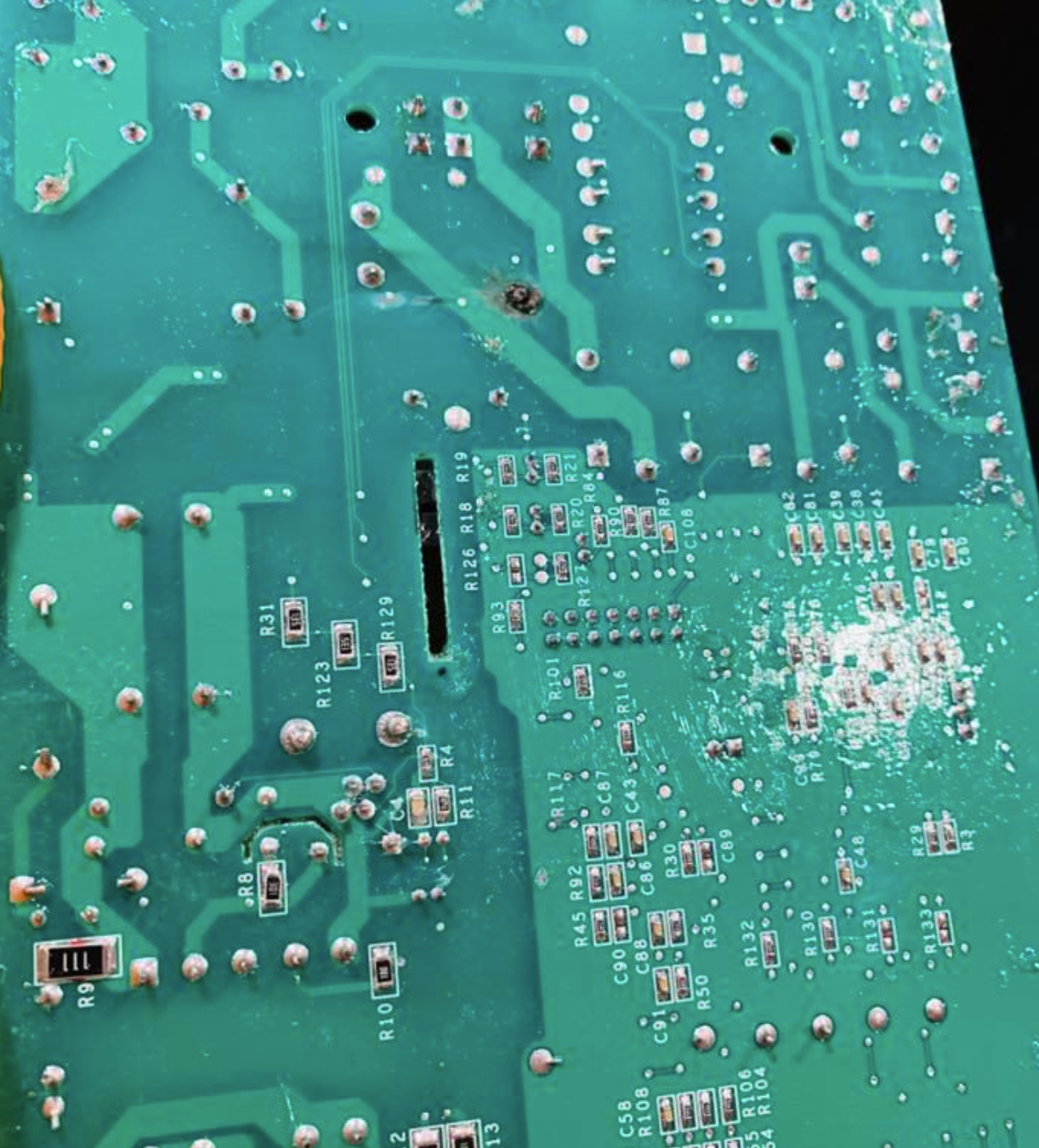 A close up of a green motherboard with a hole in it