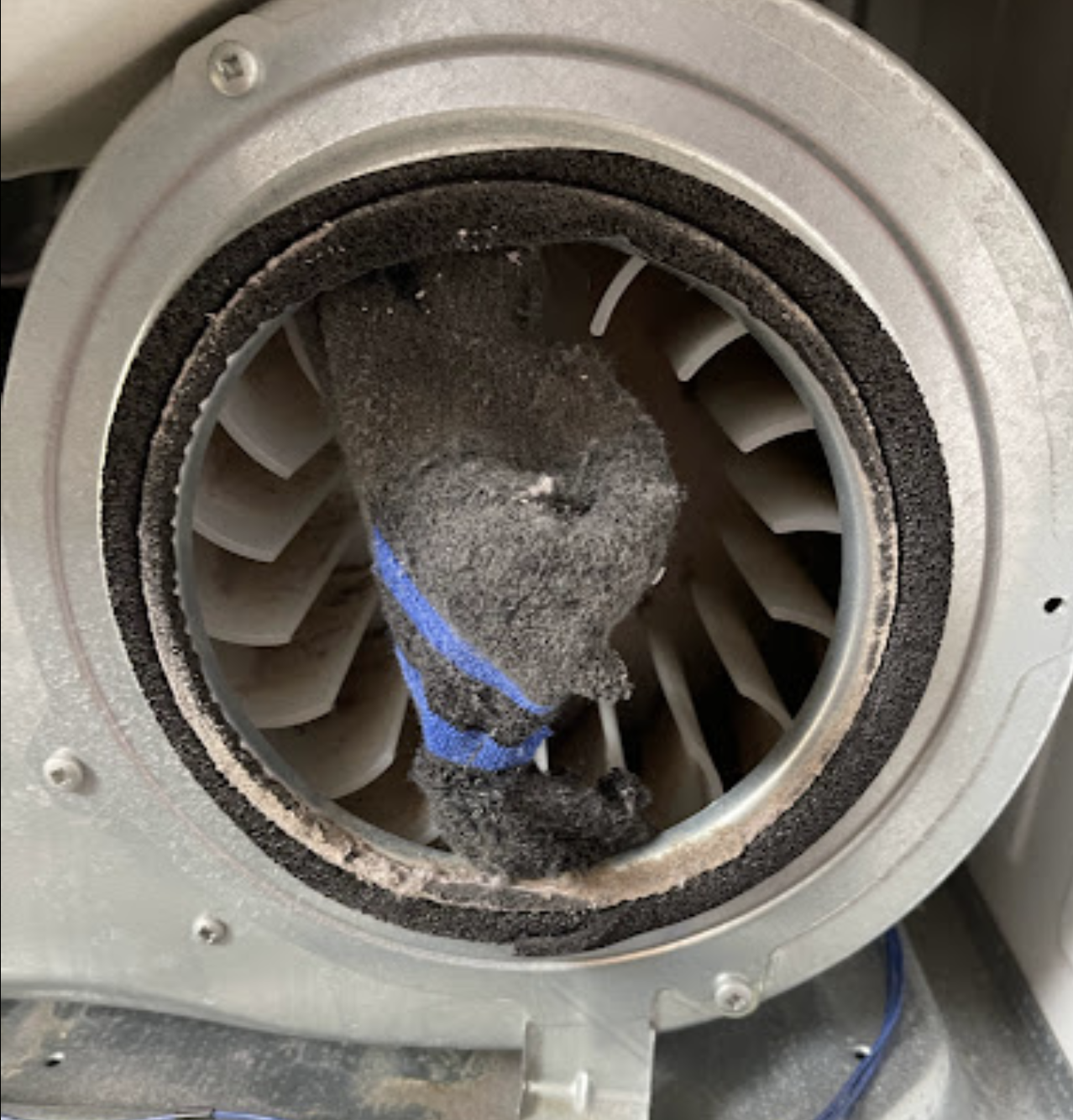 A close up of a dirty fan with a blue band around it