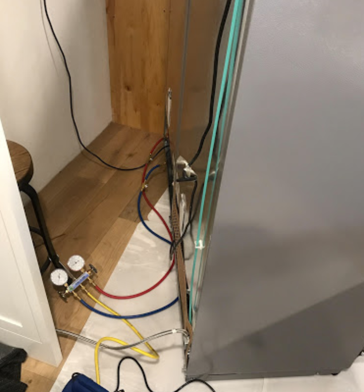 A refrigerator with a bunch of wires coming out of it