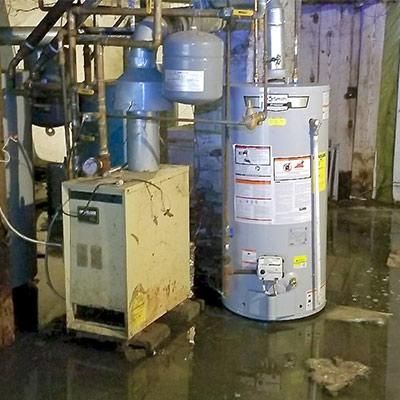A water heater is sitting in a flooded room