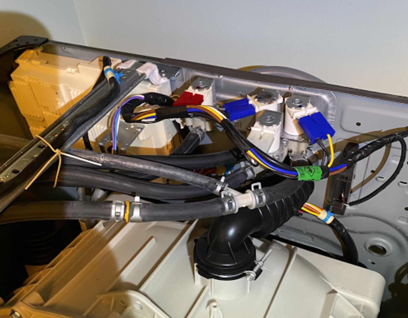 A washing machine with a lot of wires coming out of it