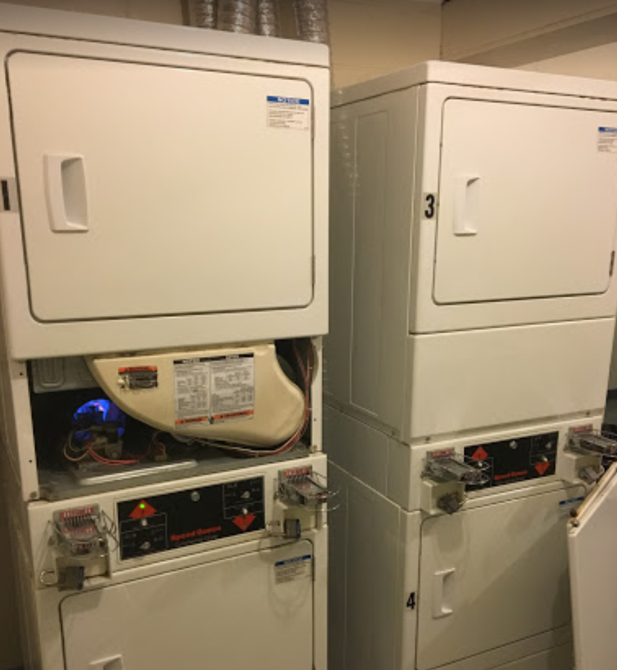 A washer and dryer are stacked on top of each other in a laundromat