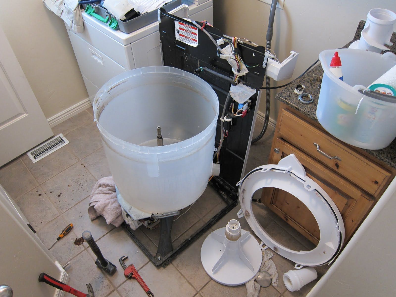 A washer and dryer are being repaired in a laundry room