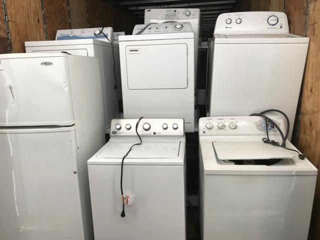 A bunch of white appliances are stacked on top of each other in a room.