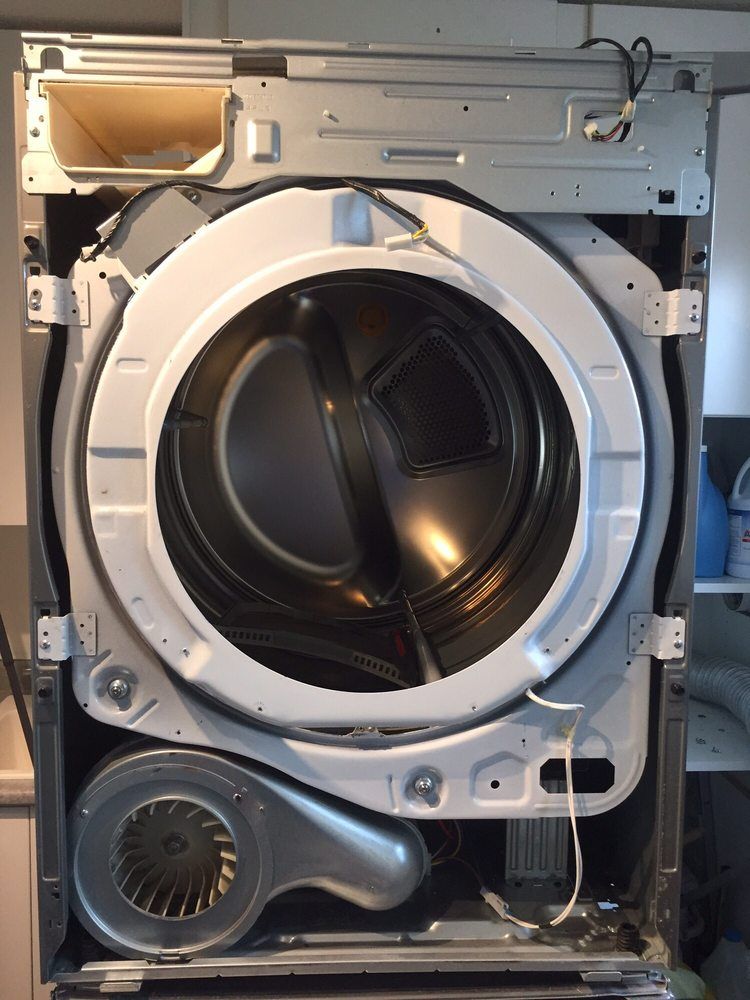 The inside of a washing machine is shown with the door open.