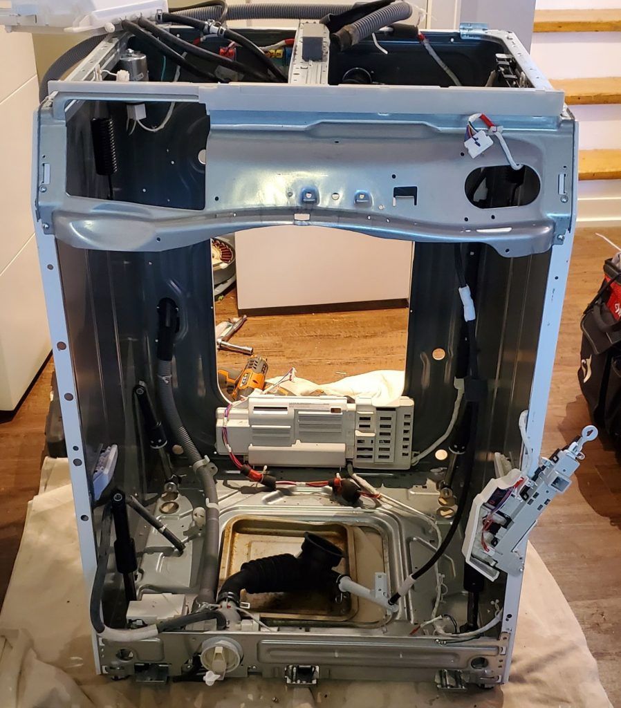 The inside of a washing machine is being disassembled