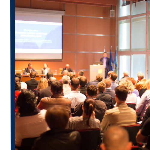 Blue and white trade show booth with cylindrical display and small table.
