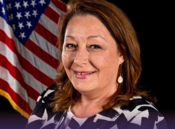 Blue and white trade show booth with cylindrical display and small table.